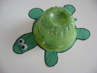 a green turtle shaped container with googly eyes