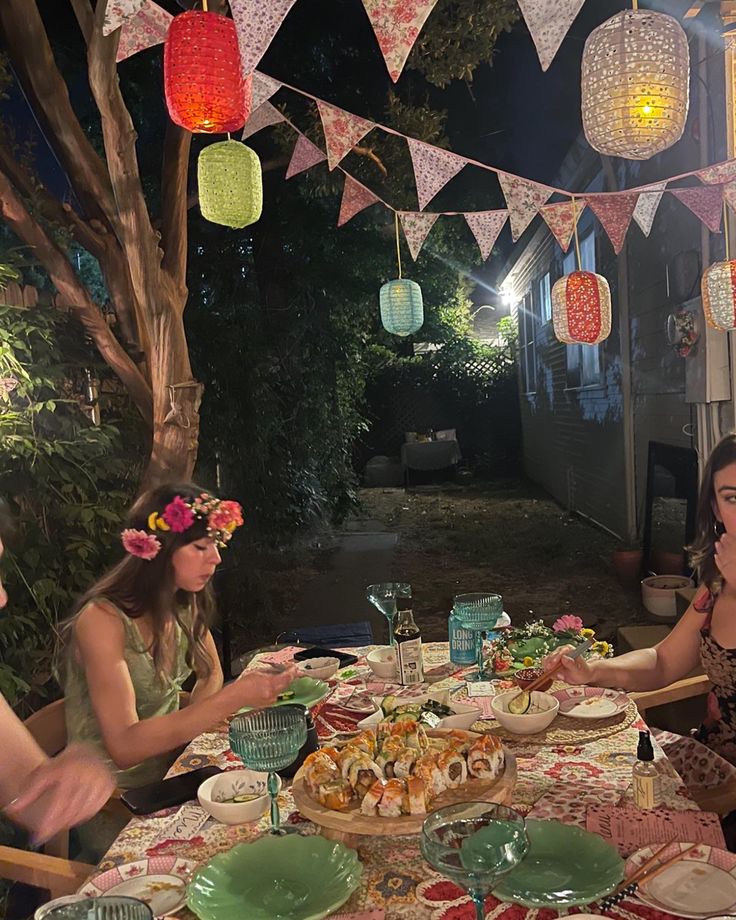 a group of people sitting around a table with plates and food in front of them