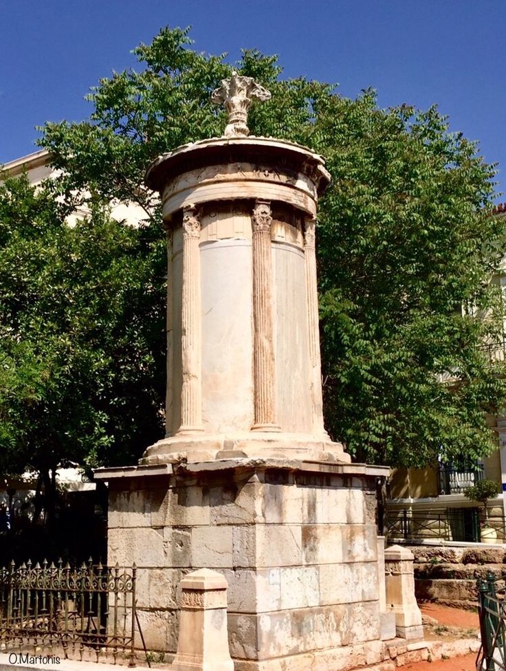 an old stone pillar in the middle of a park