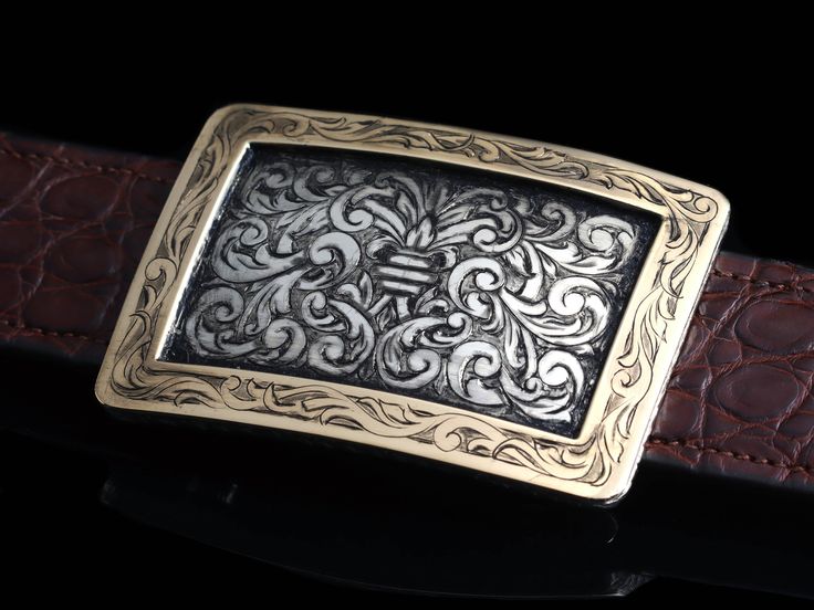 The Yellow Gold Baker Ford by Comstock Heritage is a 1.5" Sterling Silver "Baker" shaped buckles featuring an engraved wide badge border made of 14k yellow gold and our new "Ford" style hand engraving in the center. This piece is heavy gauge and colorful all in one beautiful package. Measures 2 ¼" x 3 ¼" Fits up to a 1 ½" belt strap Classic Formal Belt Buckles With Engraved Logo, Elegant Engraved Gold Belt Buckles, Hand Tooled Luxury Formal Jewelry, Formal Gold Engraved Belt Buckles, Elegant Gold Engraved Belt Buckles, Luxury Hand Tooled Jewelry For Formal Occasions, Classic Silver Hand-tooled Belt Buckle, Classic Hand Tooled Silver Belt Buckles, Elegant Formal Hand-tooled Belt Buckles