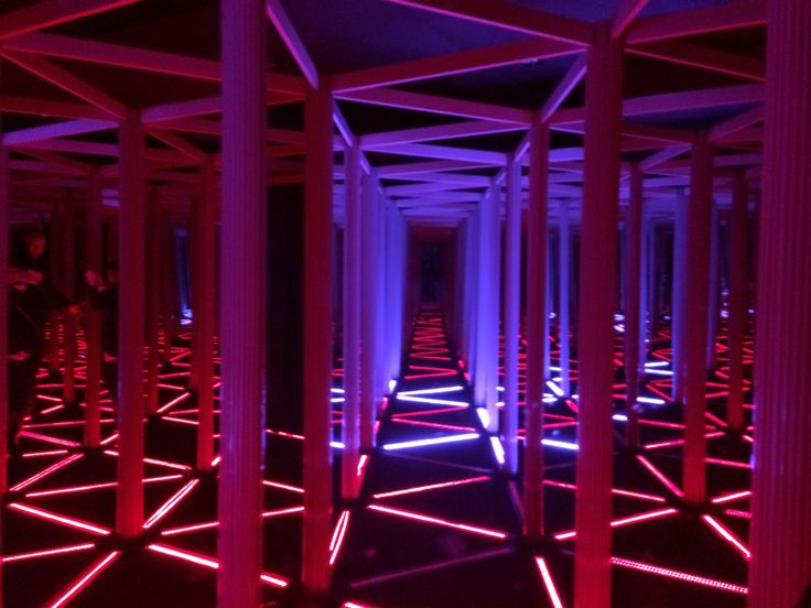 rows of columns lit up with red and blue lights in the middle of an empty room