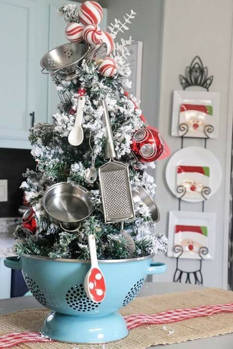 a christmas tree decorated with kitchen utensils and candy canes in a colander