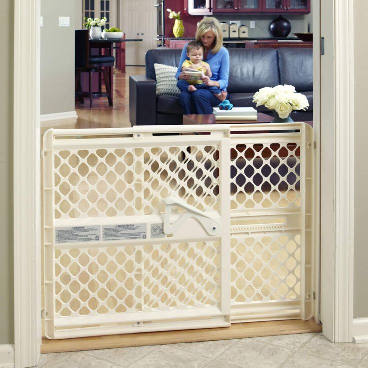 a woman sitting on a couch with a baby in her lap next to a living room