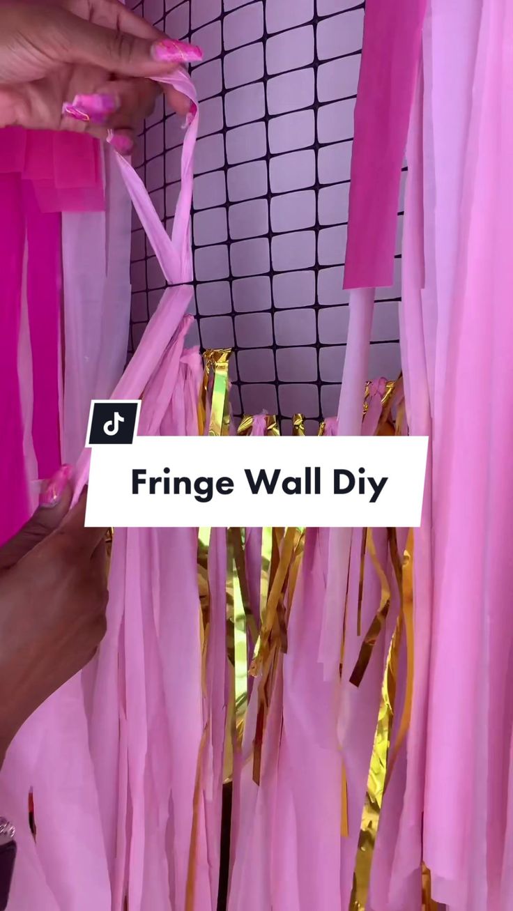 pink and gold streamers hanging from a wall with the words fringe wall diy