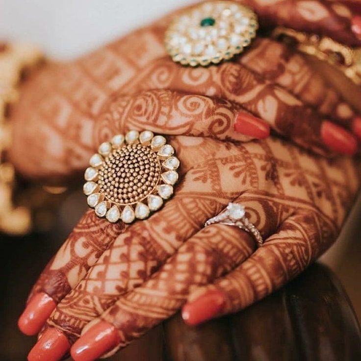 a woman's hands with henna and rings on them