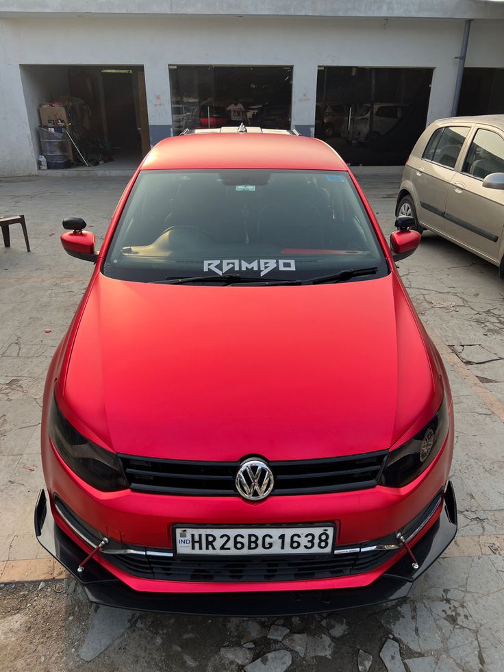 a red car parked in front of a garage