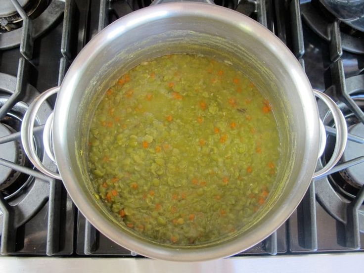 a pot filled with green liquid sitting on top of a stove