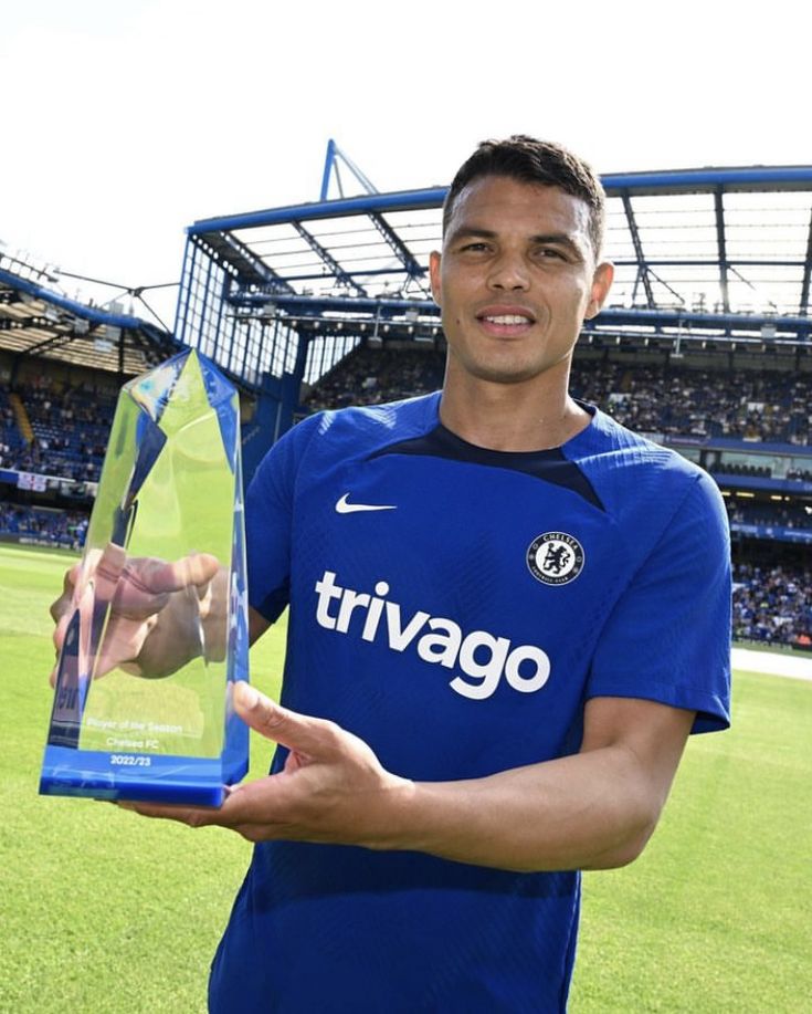 a soccer player is holding up his award