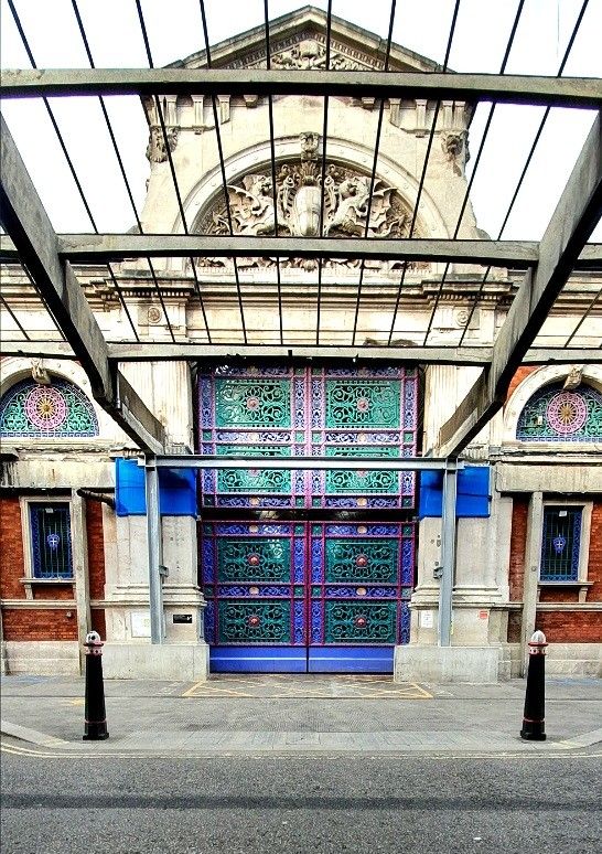 an old building with blue and green doors