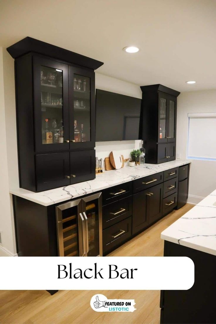 an empty kitchen with black cabinets and marble counter tops, wood flooring and wooden floors