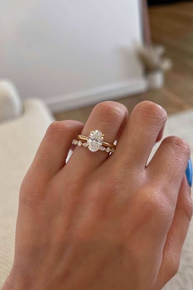 a woman's hand with a ring on it and a diamond in the middle