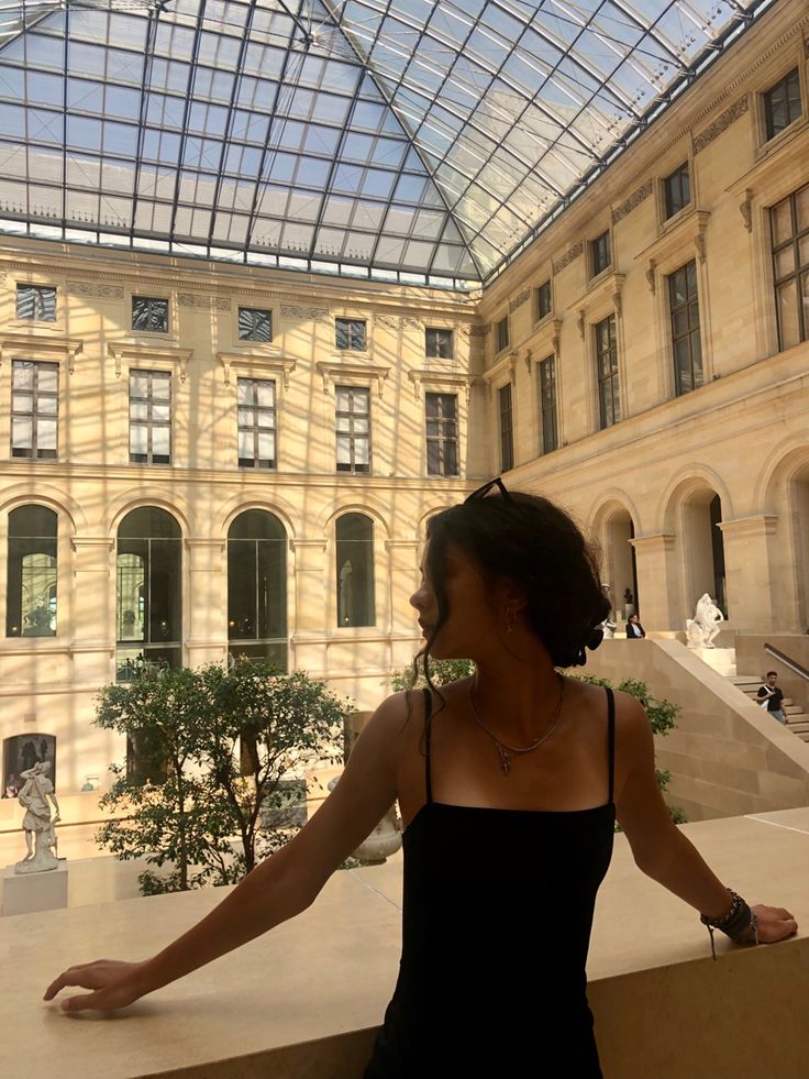 a woman standing in front of a glass ceiling