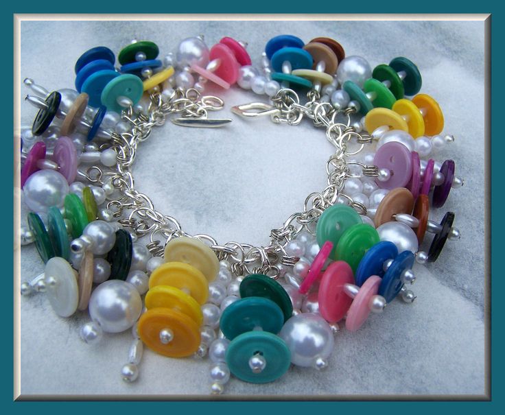 a colorful bracelet with lots of buttons and pearls on the clasp is featured in this photo