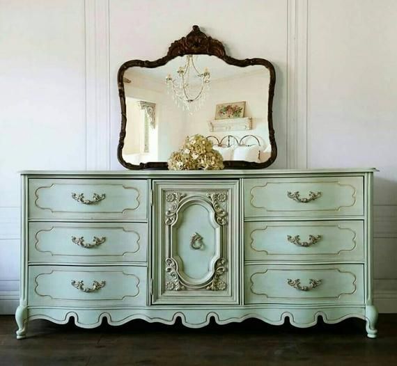 an ornate dresser with a mirror on top