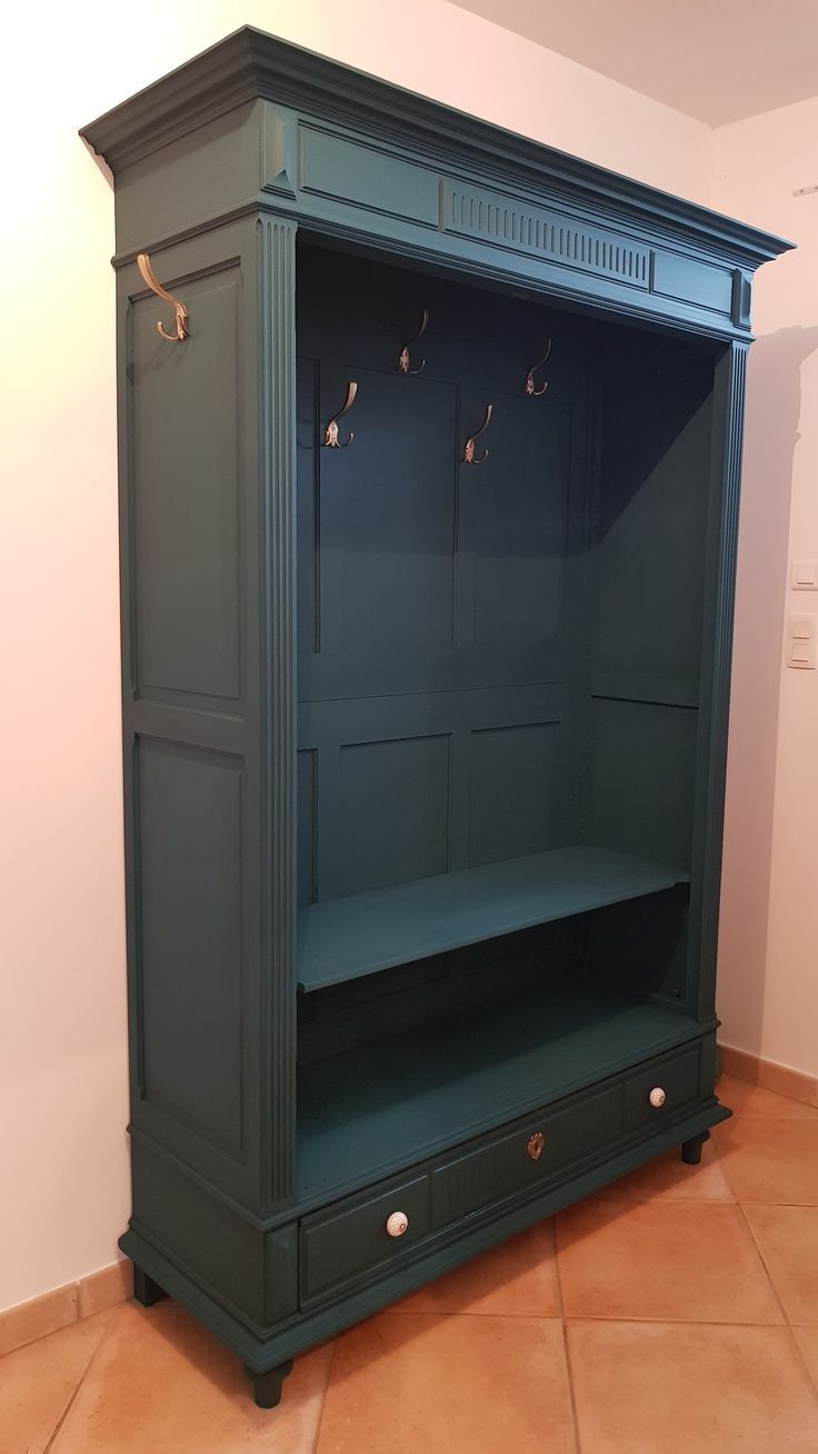 a large green cabinet with two doors and shelves on the bottom, in front of a white wall