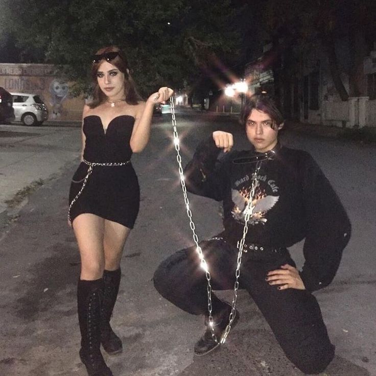 two people dressed up in costumes posing for the camera with chains attached to their ankles