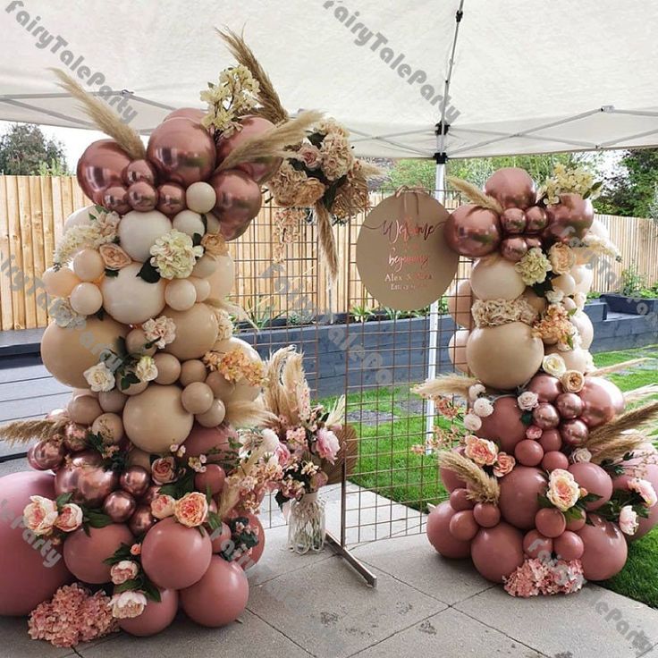 an outdoor area with pink and gold decorations on the top, flowers in vases below