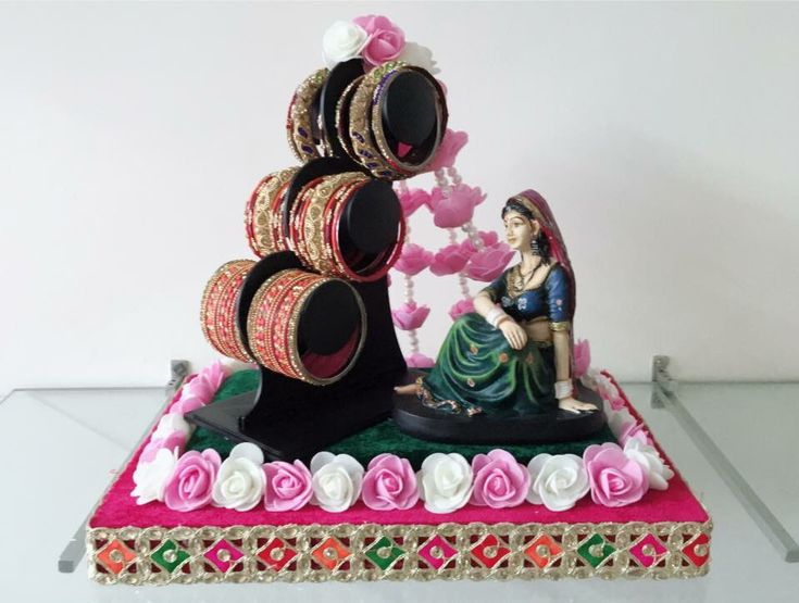 there is a cake that looks like a woman with many bracelets on her head