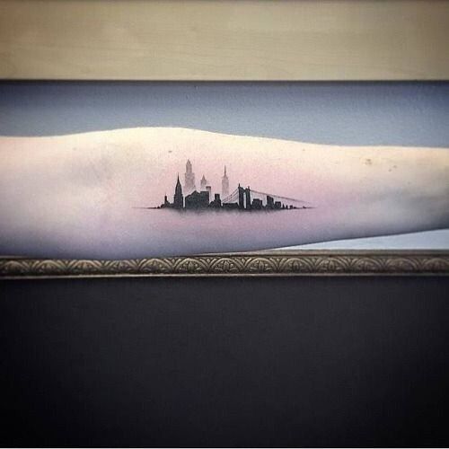 a city skyline tattoo on the arm