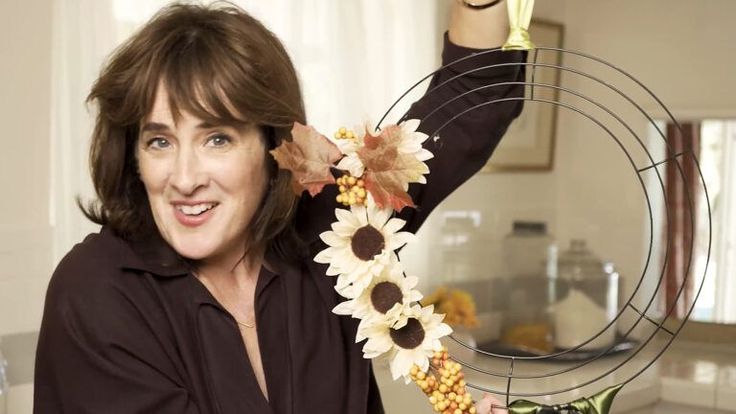 a woman is holding flowers in front of her face while posing for a photo with the sunflowers