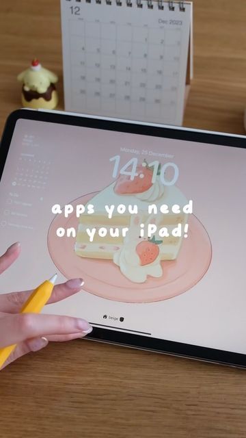 a person is playing on an ipad with the app's keyboard and cupcakes in the background