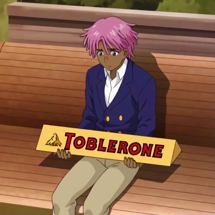 a man sitting on top of a wooden bench holding a sign that says toblerone