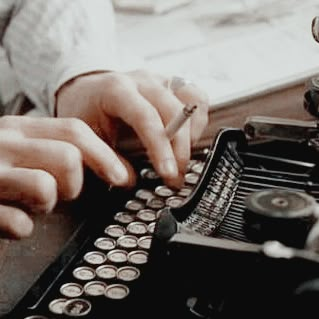 a person typing on an old fashioned typewriter