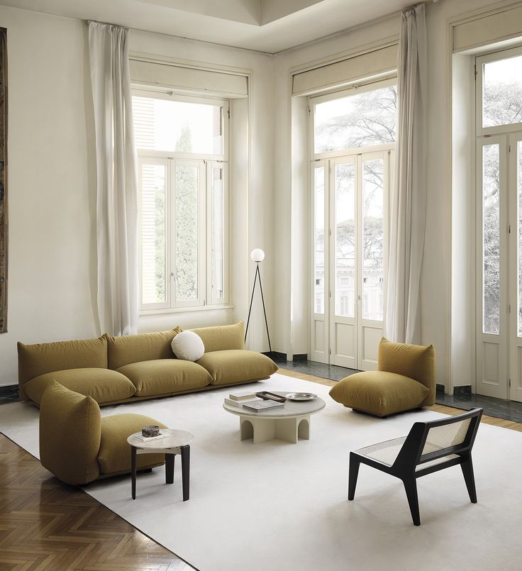 a living room filled with furniture and large windows