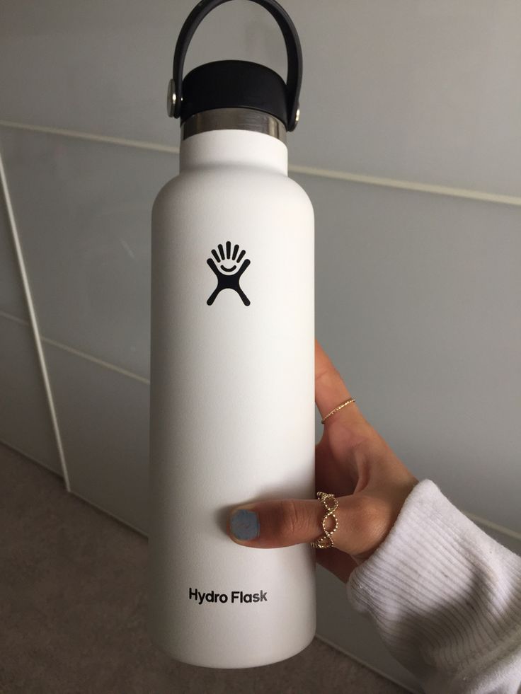 a person holding up a white hydro flask