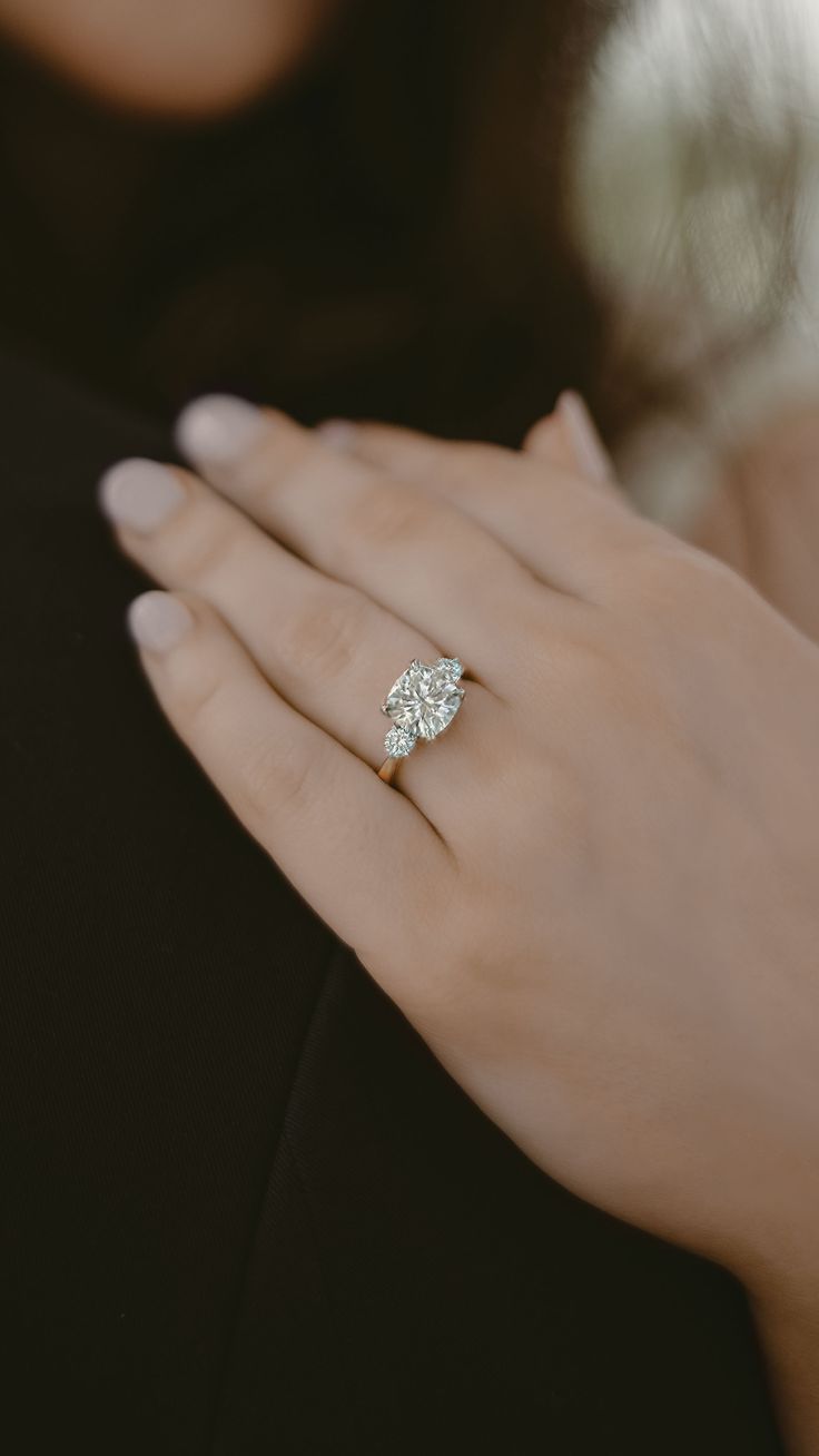 a woman's hand with a diamond ring on it