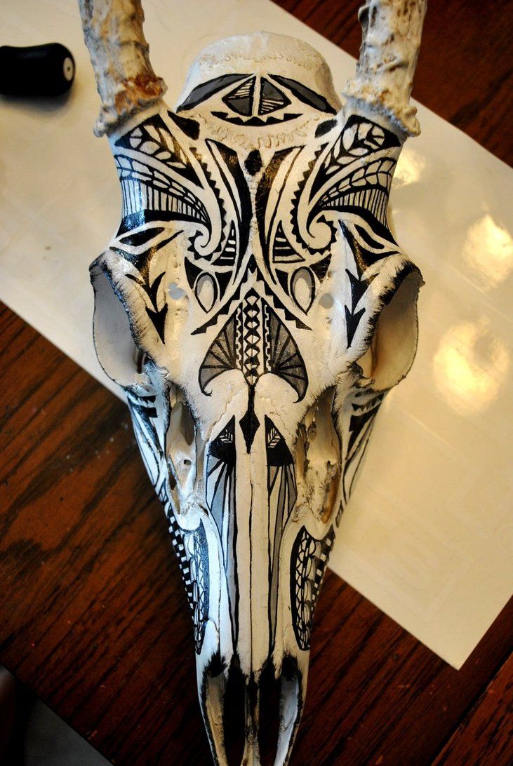 an animal skull with intricate designs on it's face sitting on top of a table