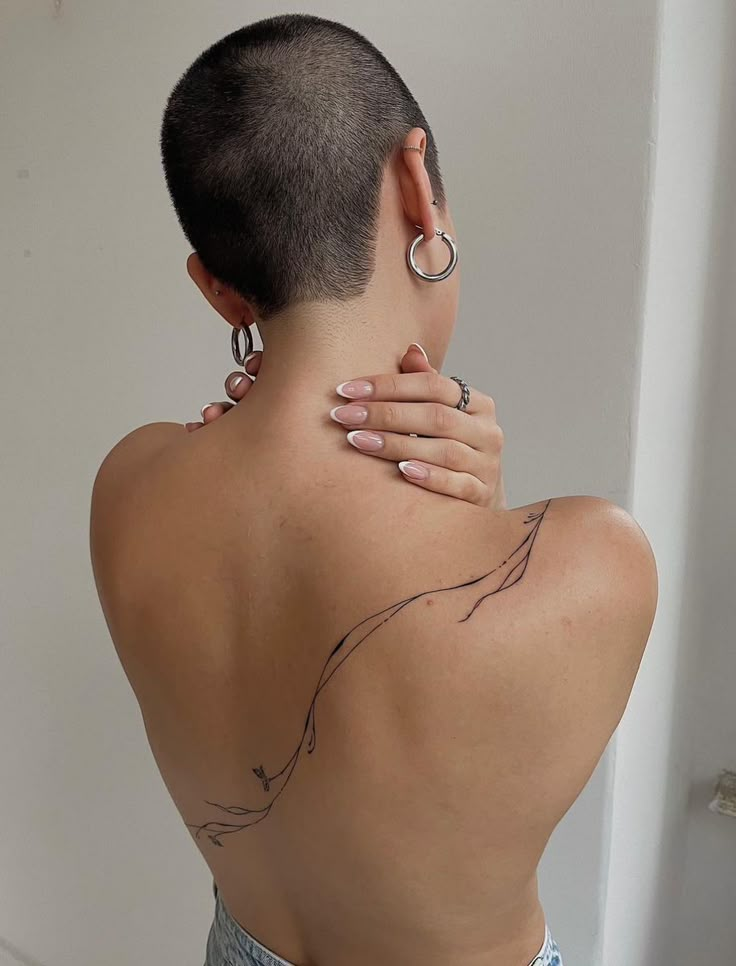 the back of a woman's neck with tattoos on it