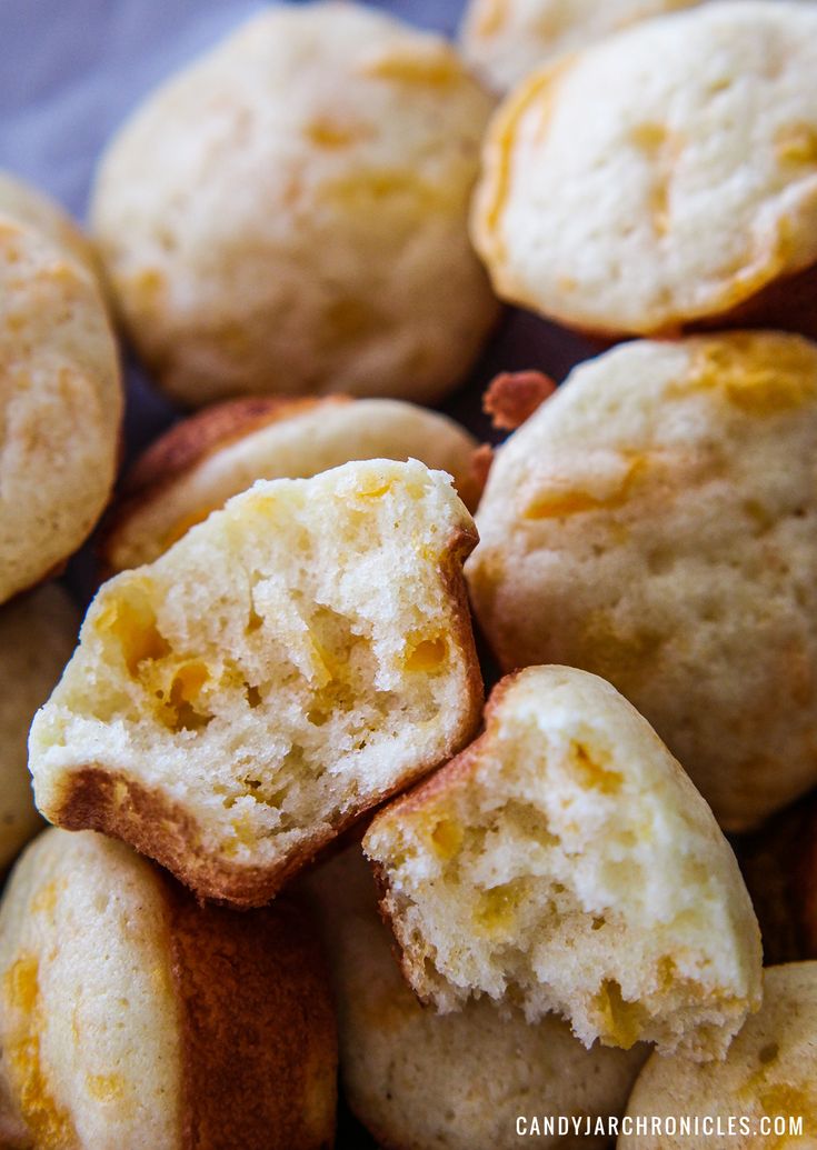 a pile of freshly baked muffins sitting on top of a blue table cloth