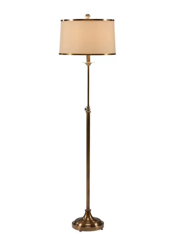 a floor lamp with a white shade on it's base and a gold finish