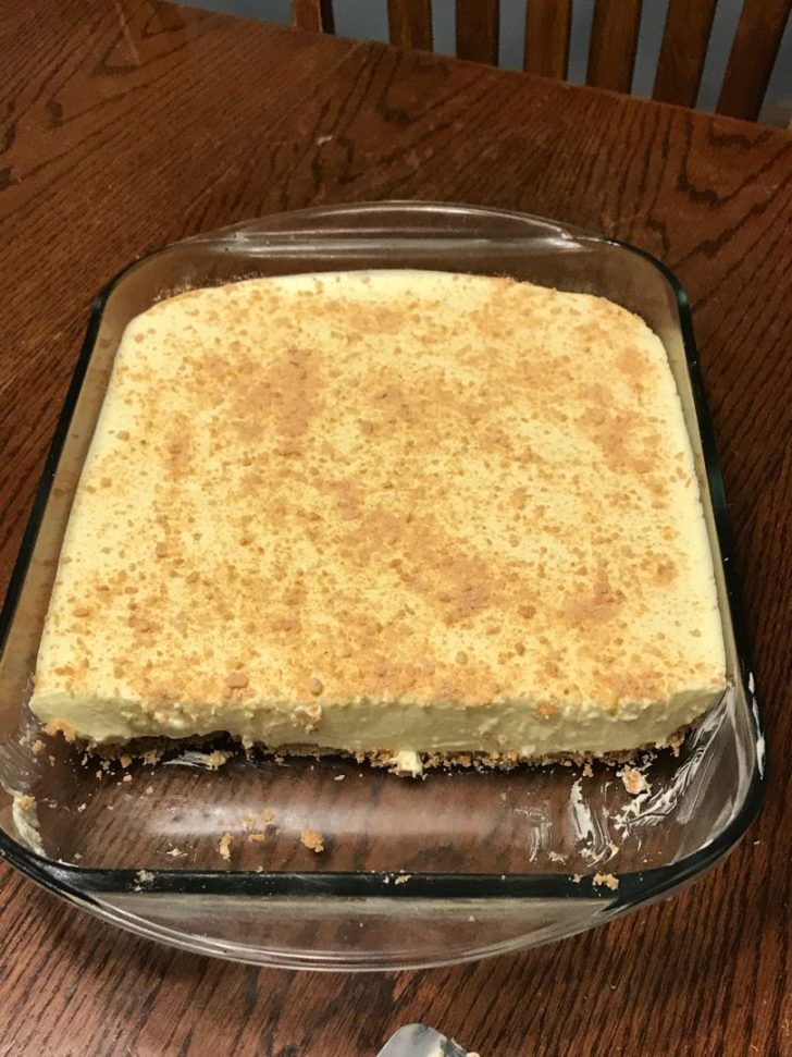 a cake sitting on top of a wooden table next to a knife and fork in front of it