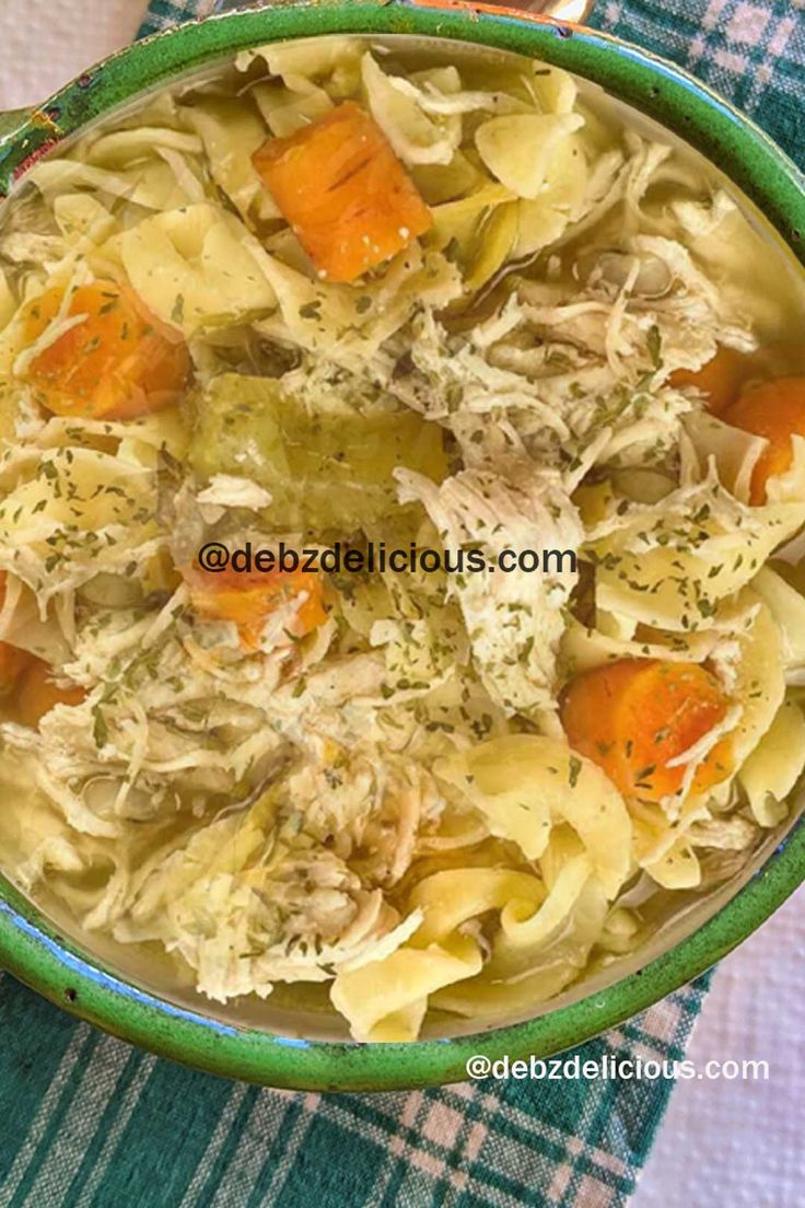 a bowl of chicken noodle soup with carrots and celery