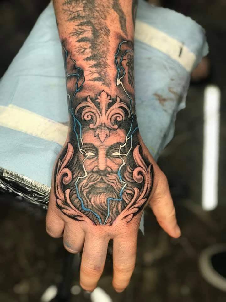 a man's hand with a tattoo on it