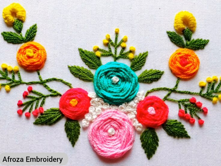 an embroidered piece with flowers and leaves on it