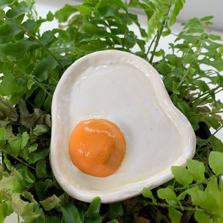 an egg shell sitting on top of green plants