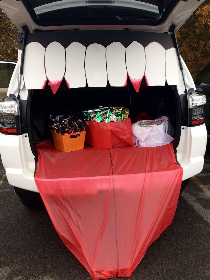 the back end of a white van with an open trunk and red cloth on it