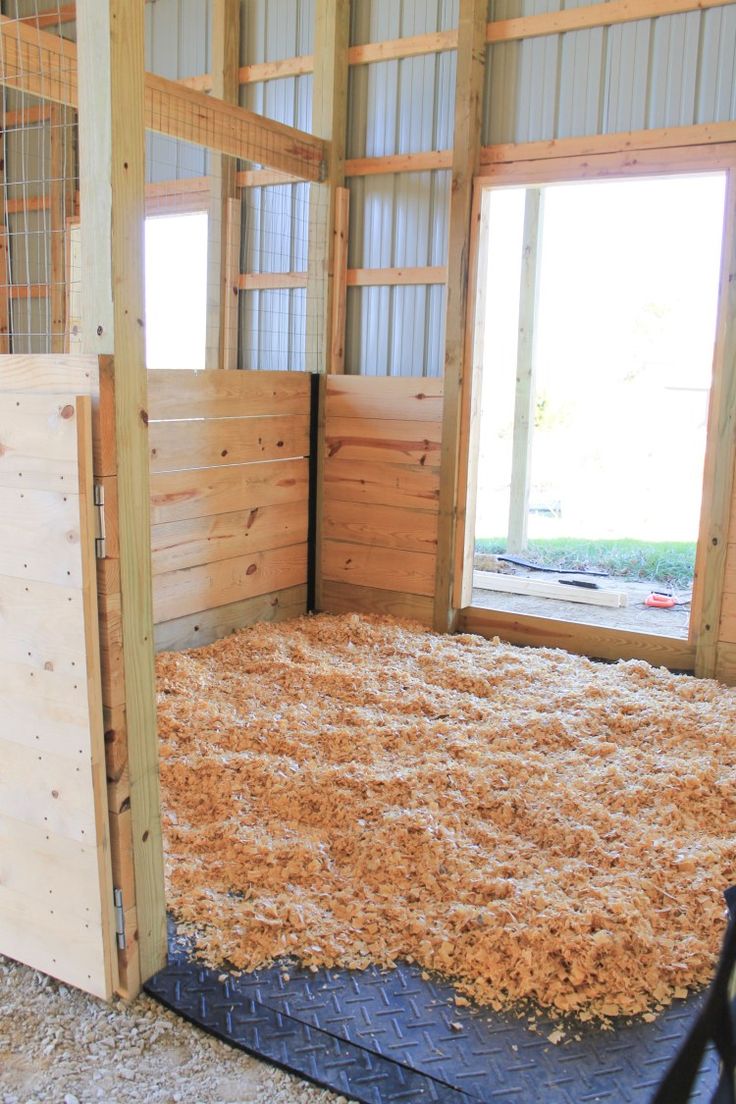 the inside of a barn with hay on the floor