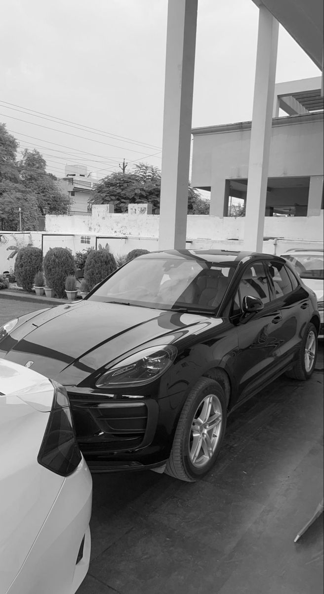 a black porsche cayen is parked at a gas station