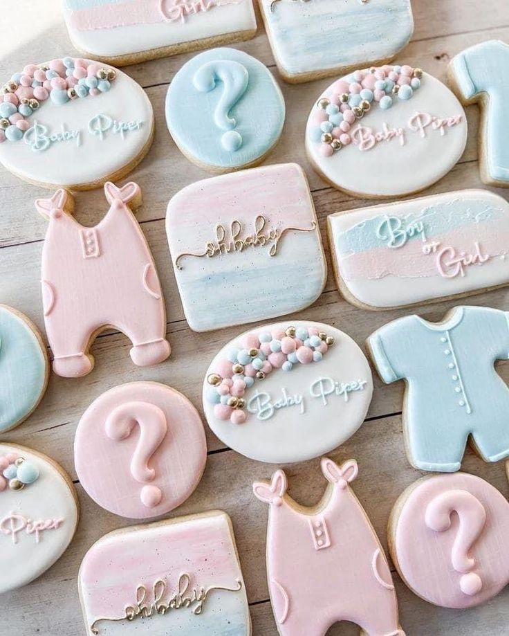 baby shower cookies with pink, blue and white icing on a wooden table top