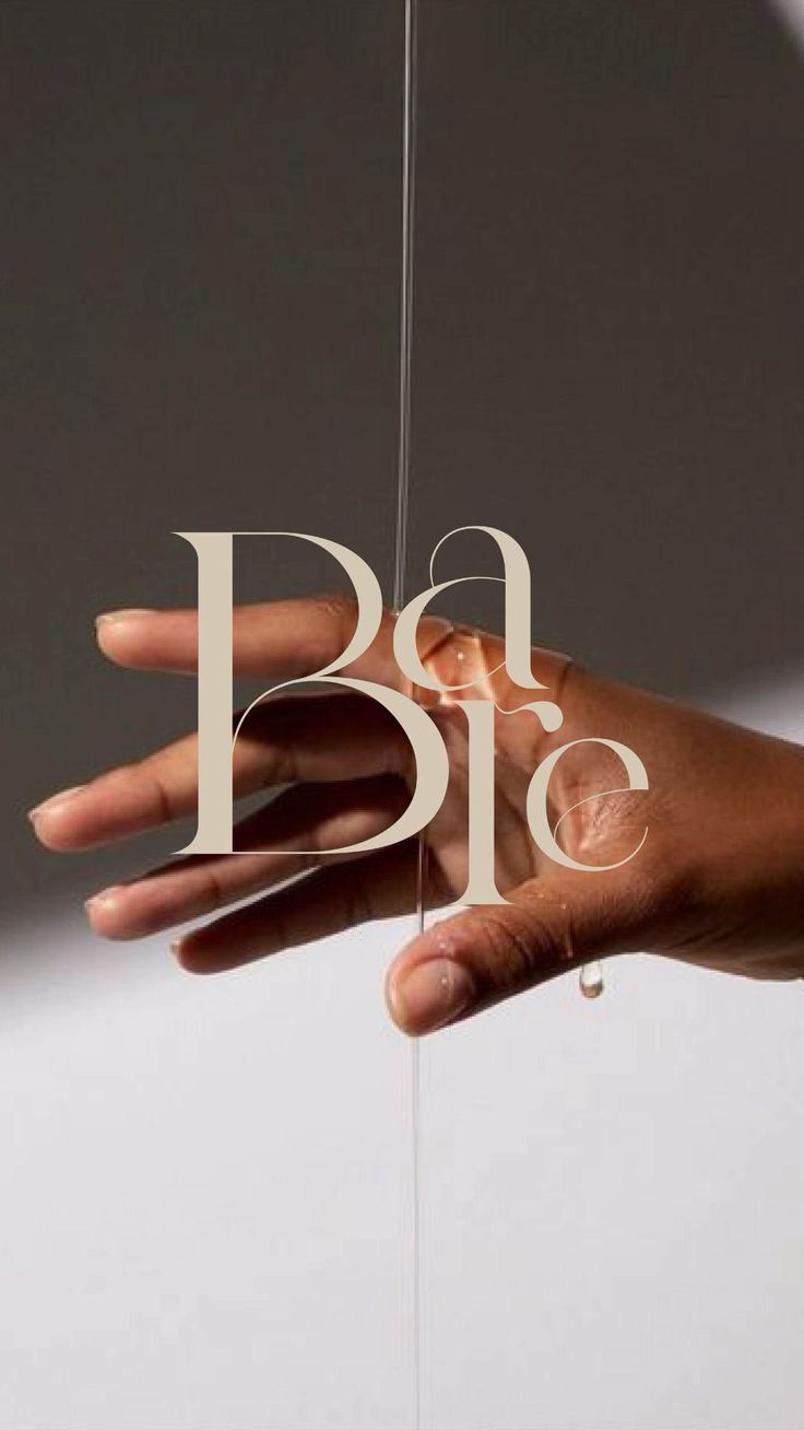 a person's hand holding the word p is spelled with white paper and string