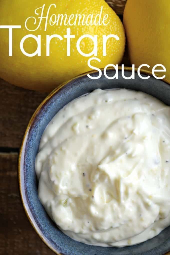 homemade tartar sauce in a bowl next to lemons