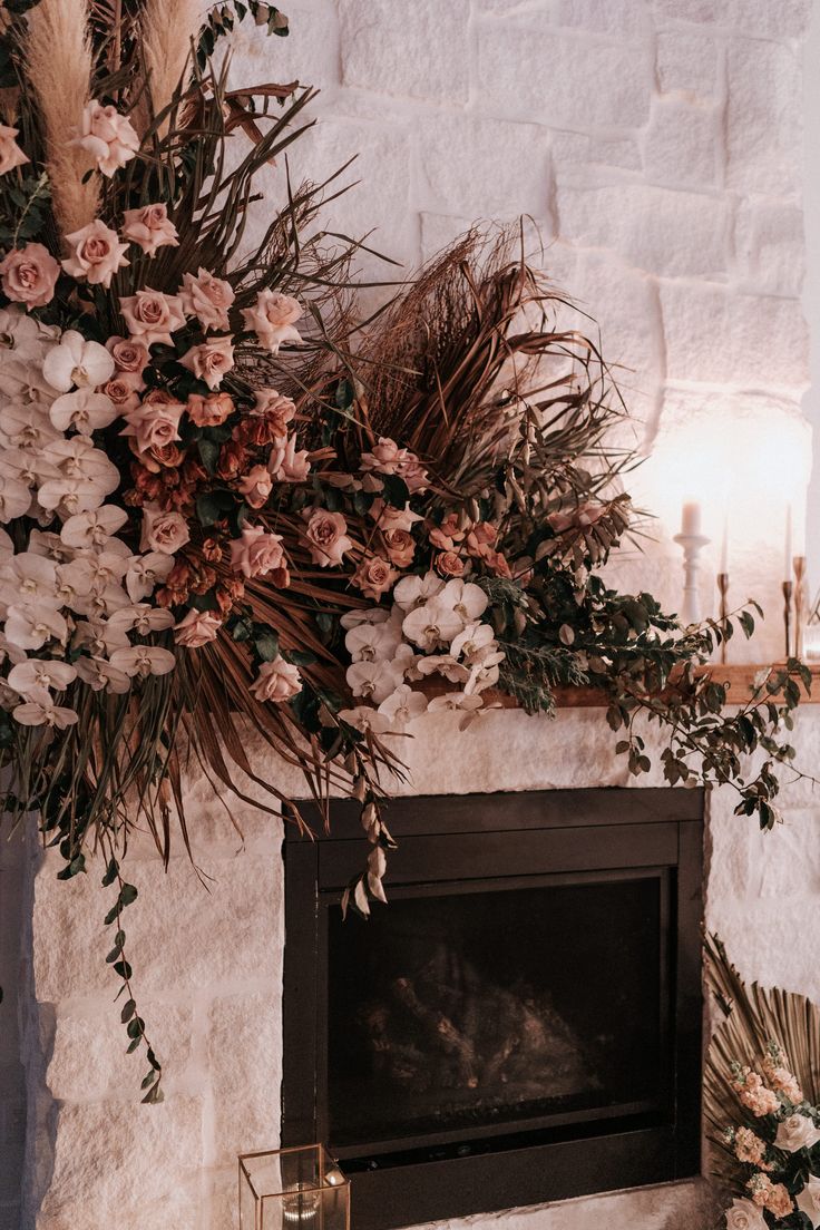 a fireplace decorated with flowers and greenery