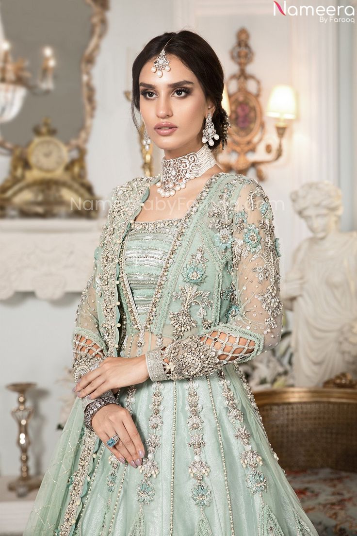 Premium Designer Peach and Sea Green Lehenga is emblazoned in work of kora, dabka, sequins, and zardozi work done on Gown paired with tissue fabric lehenga and net embellished dupatta in sea green color. Gown: Elegant Front Open gown is Heavily Embellished in work of tilla, sequins, dabka and kora work on gown including its front and back along with heavily embellished borders of the silver color on gown further enhanced with dangling pearls and tassels on the bottom and sleeves of the dress tha Sea Green Lehenga, Sea Green Dress, Maria B Bridal, Mehendi Dress, Net Gowns, Backless Gown, Green Lehenga, Pink Lehenga, Anarkali Gown