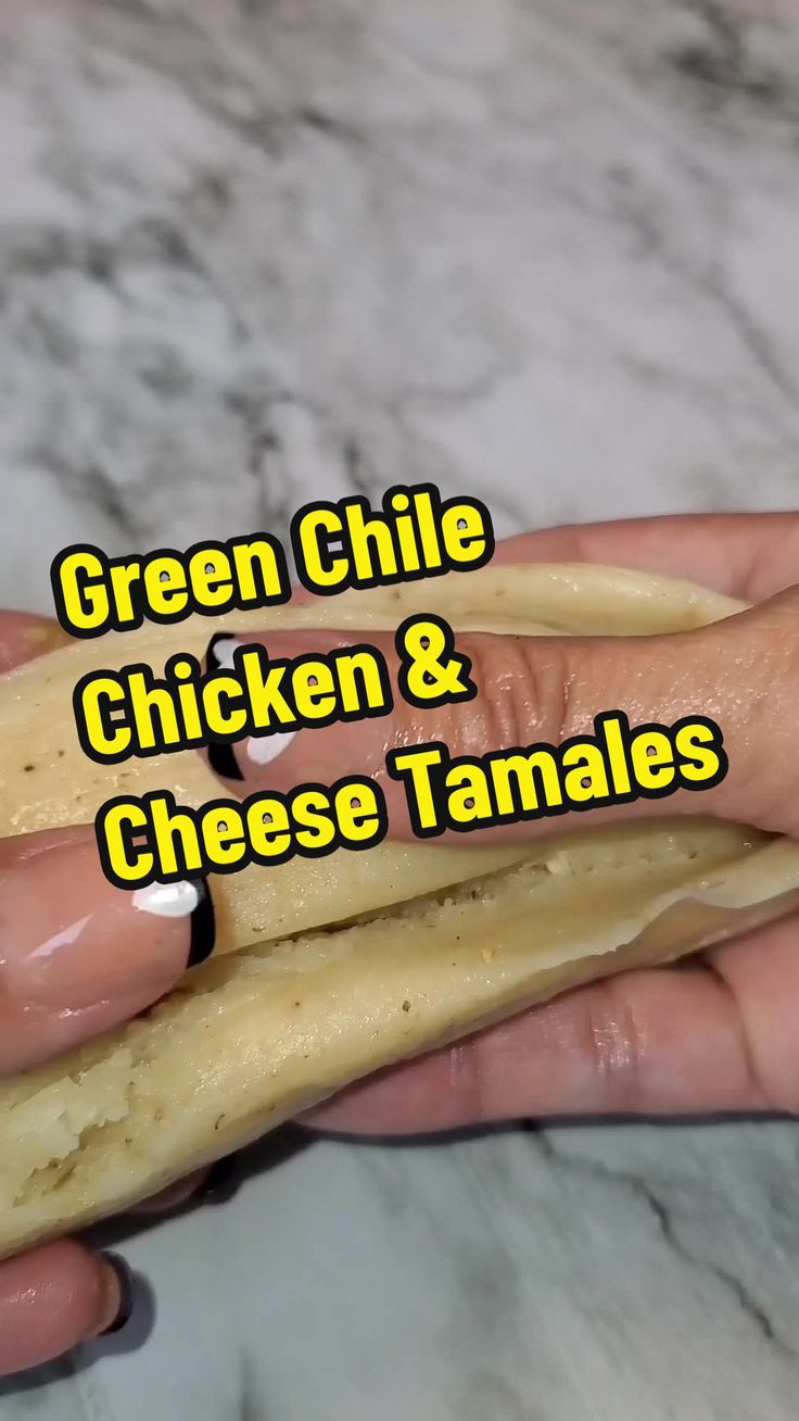 green chile chicken and cheese tamales in someone's hand with the words green chile chicken and cheese tamales