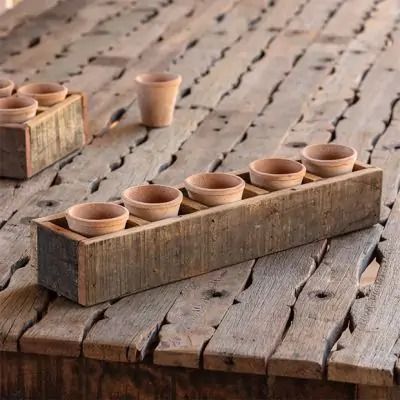 a wooden table topped with lots of small cups