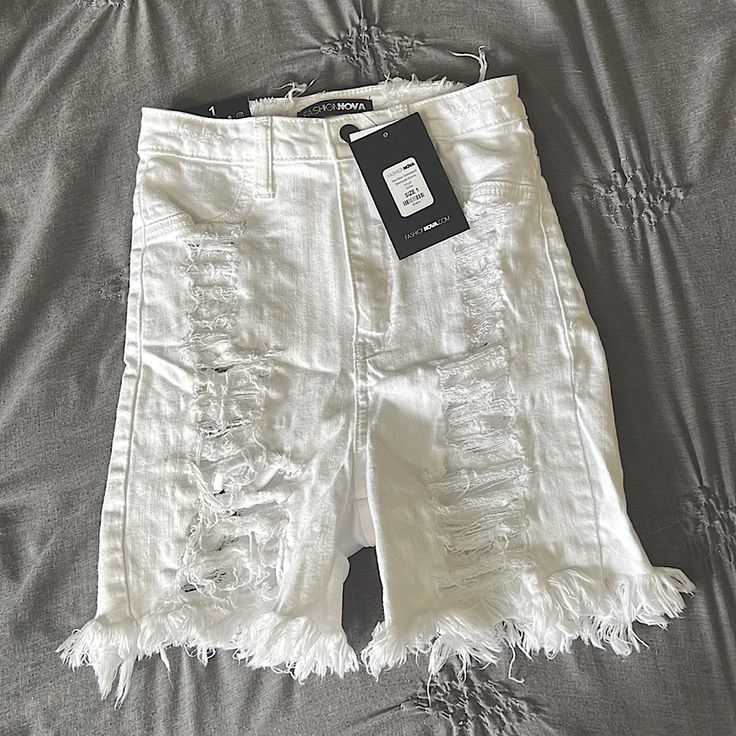 Size 1 White Fashion Nova Distressed Shorts. They Run True To Size And Are Super Stretchy! They Are High Waisted And Come Down About Mid Thigh Length. Only Tried One, Never Worn Out. Tags Still On Them. They Have Rips On Both The Front And Back Of The Shorts, With That Being Said The Back Tears Shows Some Skin. Fitted Distressed White Bottoms, Stretch Distressed White Bottoms, White Bottoms With Frayed Hem For Beach, White Beach Bottoms With Frayed Hem, White Knee-length Jean Shorts For Summer, White Distressed High Waist Bottoms, High Waist Ripped White Bottoms, White High Waist Ripped Bottoms, High-waisted White Ripped Bottoms